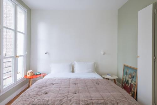 Ce lit se trouve dans un dortoir blanc doté d'une grande fenêtre. dans l'établissement Modern Rustic-style Apartment 7th arrondissement!, à Paris