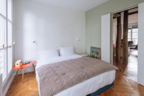 une chambre avec un grand lit et une table dans l'établissement Modern Rustic-style Apartment 7th arrondissement!, à Paris