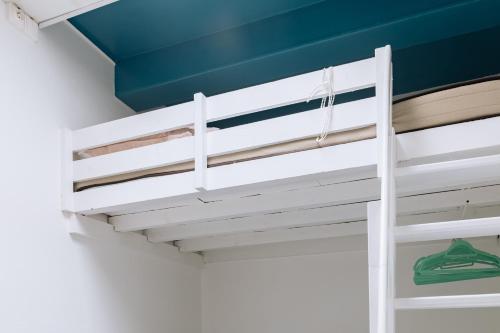 Ce lit superposé blanc se trouve dans un dortoir. dans l'établissement Chic Studio Apartment for 3 - La Villette!, à Paris
