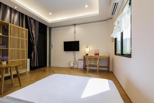 a bedroom with a bed and a desk and a tv at Wabisabi Bangkok 3 MIN To Train Station in Bangkok