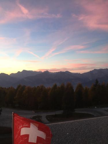 a cross flag on top of a mountain at sunset at Thyon 2000 - Vélan 319 - 2,5 pièces - 2 chambres in Les Collons