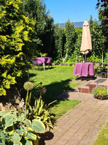 a patio with a table and an umbrella at Vila Šventoji in Šventoji