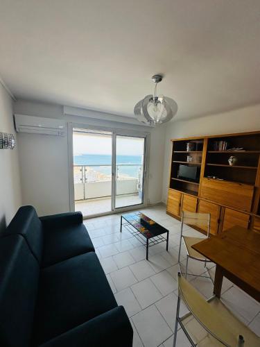 un salon avec un canapé bleu et une table dans l'établissement La plage, à Marseille