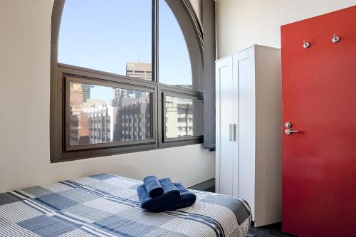 a bedroom with a bed and a large window at Wake Up! Sydney Central in Sydney