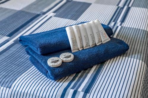 a blue towel with three pillows on a bed at Wake Up! Sydney Central in Sydney