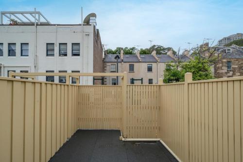 a wooden fence in front of some buildings at Harbour View Terrace House In The Heart Of The Rocks in Sydney