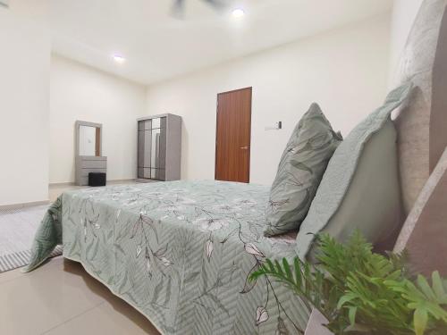 a bedroom with a bed with a blanket and pillows at Sakeenah Homestay near UUM, UNIMAP and Matrik Kedah in Changlun