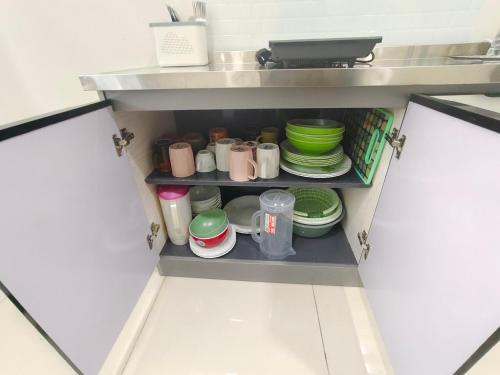 a open pantry with dishes and cups and plates at Sakeenah Homestay near UUM, UNIMAP and Matrik Kedah in Changlun