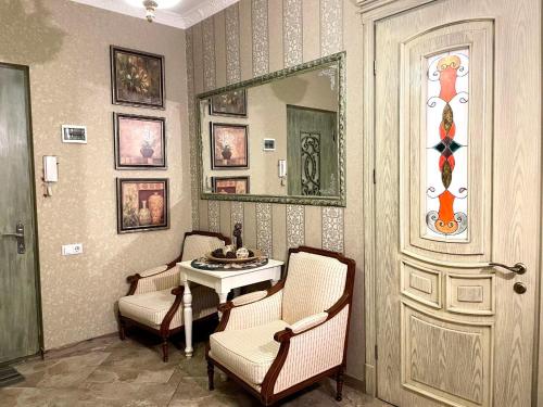 a room with two chairs and a table and a mirror at Loka Chovelidze in Tbilisi City