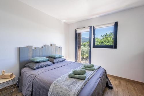 a bedroom with a large bed and a window at campdebaseventoux, vue sur le ventoux insolite in Bédoin