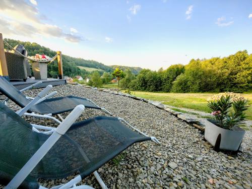 a couple of lawn chairs sitting on the gravel at Repakowa Chata in Polańczyk