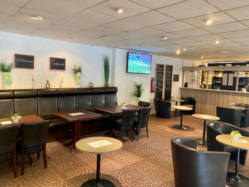 a restaurant with tables and chairs and a television at Atempause und erholsame Zeit im Harz in Braunlage