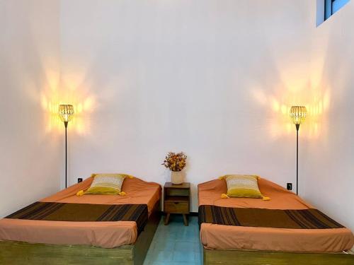 two beds sitting next to each other in a room at Casa Sofi Oaxaca in Oaxaca City