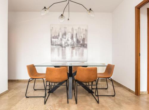 a dining room with a glass table and four chairs at Picasso Suites in Barcelona