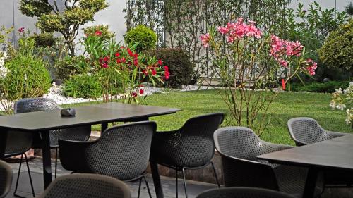a group of tables and chairs in a garden at Aniroc Signature Hotel in Arad