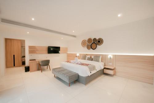 a bedroom with a bed and a table and a chair at Seminyak vila luxury 4Br near beach LAfavela in Seminyak