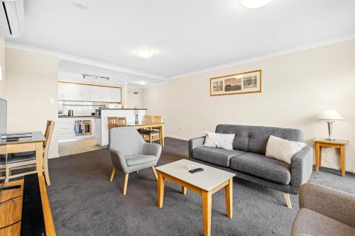 a living room with a couch and a table at Perth Family Getaway Pool & Parking in Perth