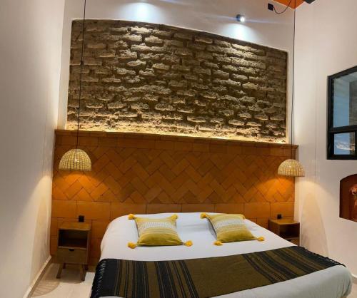a bedroom with a bed with a brick wall at Casa Sofi Oaxaca in Oaxaca City