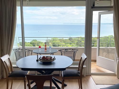 a table and chairs in a room with a view of the ocean at Baltic Panorama Suite in Timmendorfer Strand
