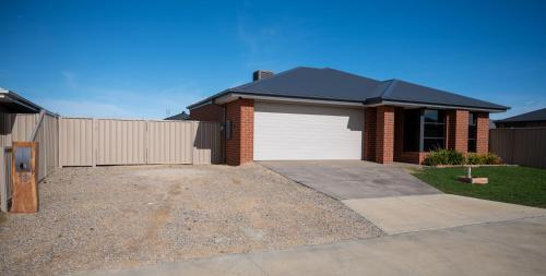a house with a white garage and a fence at Grevillea House in Echuca