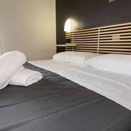 a large bed with white pillows on top of it at Hotel Quadrifoglio in Caraglio