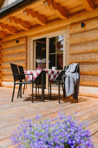 a table and chairs on a wooden deck at Na Wierchach in Wisła
