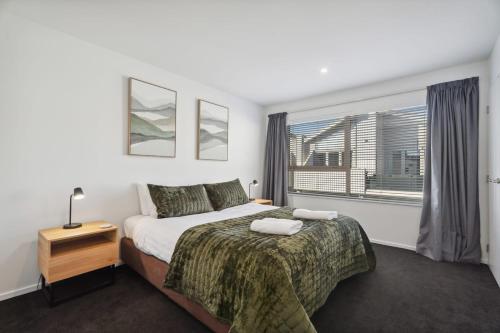 a bedroom with a large bed and a window at Alpine Retreat - 3 Bedroom in Wanaka
