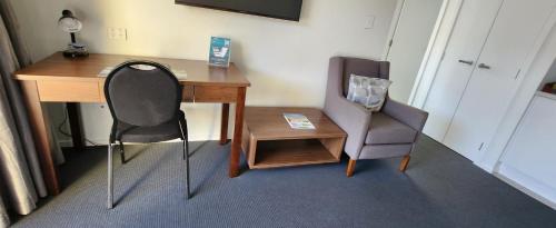 an office with a desk and a chair and a table at ASURE Central Gold Motel Cromwell in Cromwell