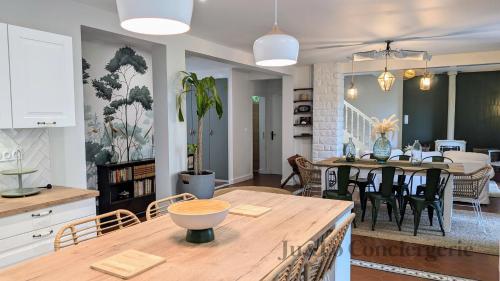 une cuisine et un salon avec une table et des chaises dans l'établissement Villa Nature Salle de Sport Jacuzzi, à Saint-Jean-la-Poterie