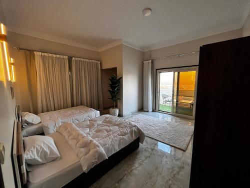 a bedroom with two beds and a large window at Nile view panoramic balcony in Cairo