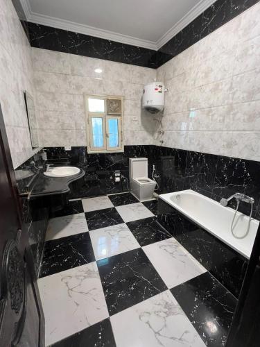 a black and white bathroom with a tub and sink at Nile view panoramic balcony in Cairo