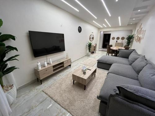 a living room with a couch and a flat screen tv at Nile view panoramic balcony in Cairo