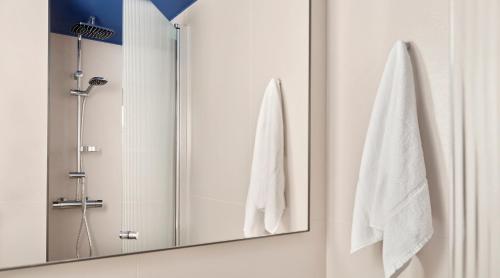 a bathroom with a mirror and white towels at Original Sokos Hotel Royal in Vaasa