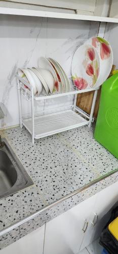 a shelf in a kitchen with plates and a sink at Chantal Beach House in San Fabian