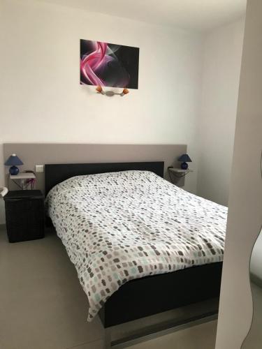 une chambre avec un lit avec une couette noire et blanche dans l'établissement Saint-Geniez d'Olt - Résidence Le Colombier, à Saint-Geniez-dʼOlt