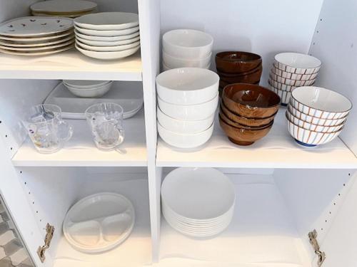 a cabinet filled with plates and bowls and dishes at Aso Lodge Otohime II in Aso