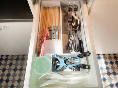 a drawer with a pair of scissors and other kitchen utensils at Aso Lodge Otohime II in Aso