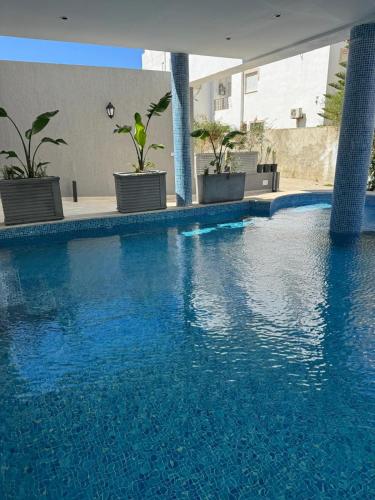 a swimming pool with blue water in a building at La Cascade Ḩammām al Ghazzāz in Kelibia