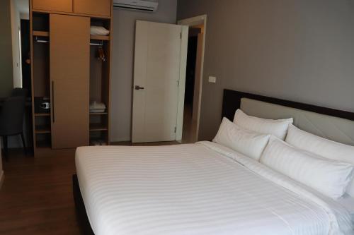 a bed with white sheets and pillows in a room at Suasana Suites Johor Bahru City Centre in Johor Bahru