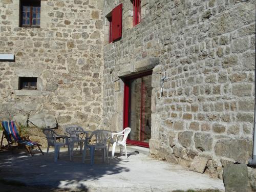 una mesa y sillas frente a un edificio de ladrillo en La Ferme d'Adèle, en Tence