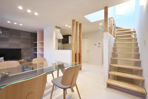 a kitchen and dining room with a glass counter and stairs at いっぷく-家族やグループ旅行に最適-愛犬と泊まれる宿 in Kanazawa