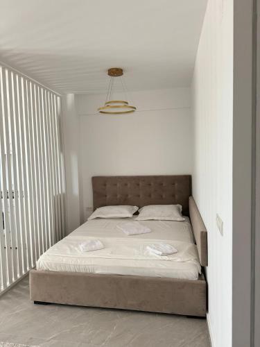 a bed in a white bedroom with a white wall at Studio Saturn Seven Palms in Saturn