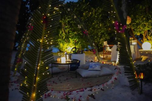 a patio with a table and a couch and lights at Ycona Eco-Luxury Resort, Zanzibar in Dikoni