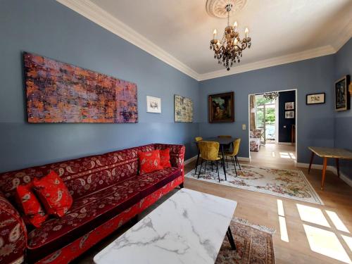 a living room with a red couch and a table at ArtHouse Am Kurpark Bad Schandau in Bad Schandau