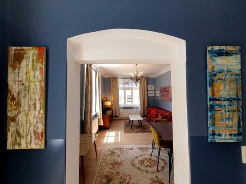 a hallway with blue walls and a living room at ArtHouse Am Kurpark Bad Schandau in Bad Schandau