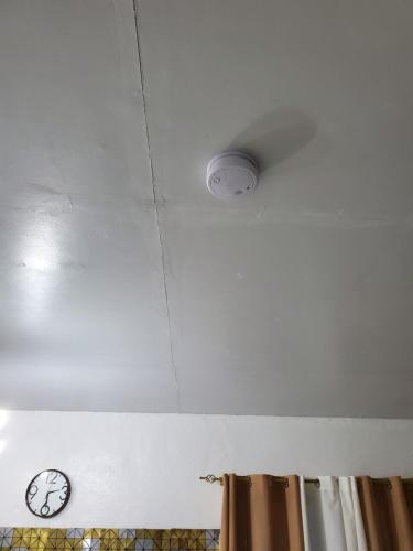 a ceiling with a clock and a light on it at Chantal Beach House in San Fabian