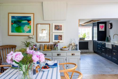 a kitchen with a table with flowers on it at Barton Cottage Bed and Breakfast in Broadmayne