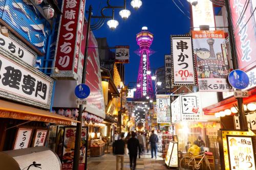 a city street with many signs and people walking down a street at Hotel Osaka Castle in Osaka