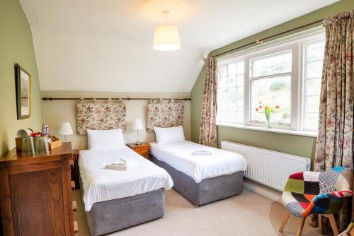 a bedroom with two beds and a window at Stanley Ghyll House in Holmrook