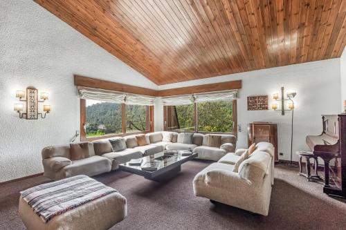 una gran sala de estar con sofás y un piano en Casa Gran, en Sant Quirze Safaja